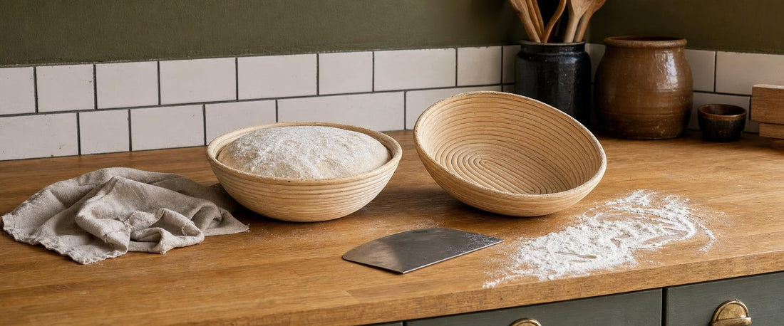 Rund og oval hævekurv i rattan med melet surdej og en dejskraber på et køkkenbord
