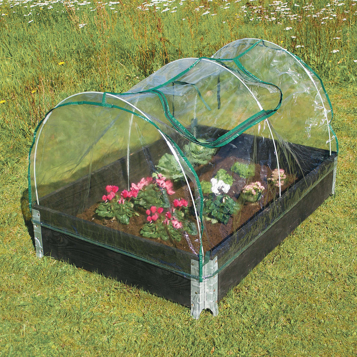 Lavt buet minidrivhus over højbed med blomster