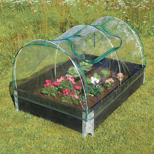 Lavt buet minidrivhus over højbed med blomster